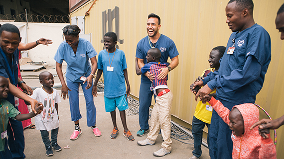 Doctors and patience dancing in front of MSC container