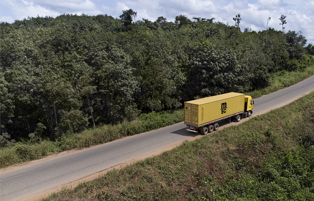 MSC container being moved by truck through the landscape of trees